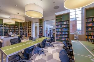 IET library desks with chairs surrounded by bookshelves