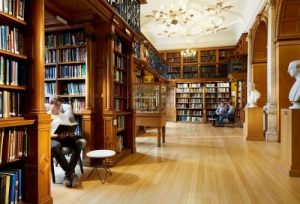 Institution of Mechanical Engineers library with wooden shelves and a people sitting in chairs reading